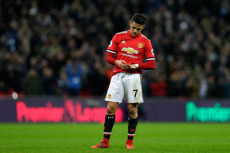 Manchester United's Alexis Sanchez looks at his hand as Tottenham's Harry Kane takes a free kick during the English Premier League soccer match between Tottenham Hotspur and Manchester United at Wembley stadium, in London, Wednesday Jan. 31, 2018. (AP Photo/Alastair Grant)