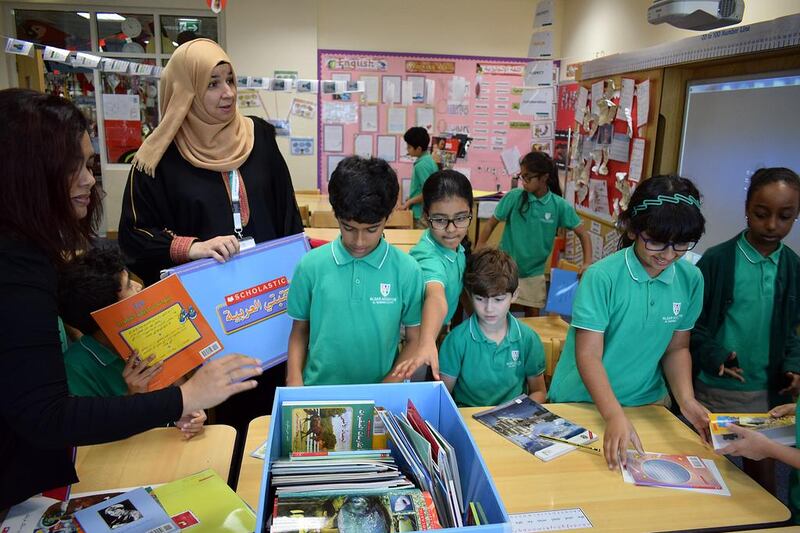 Students at Al Yasmina School receive books from Scholastic as part of the #UAEReads Challenge. Arabic teacher Nagat Eid, left, says the challenges given to her young readers at schools maintain their interest in literacy. Delores Johnson / The National