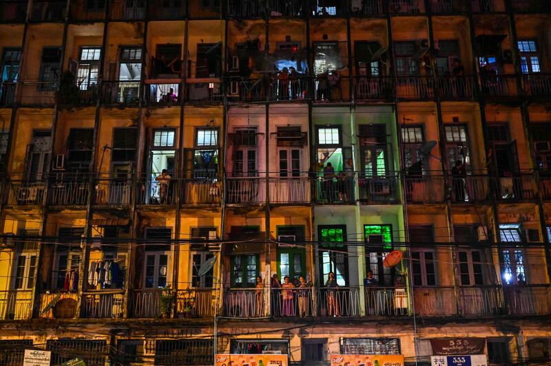 Residents watch from their building as people make noise by hitting objects after calls for protest went out on social media in Yangon. AFP