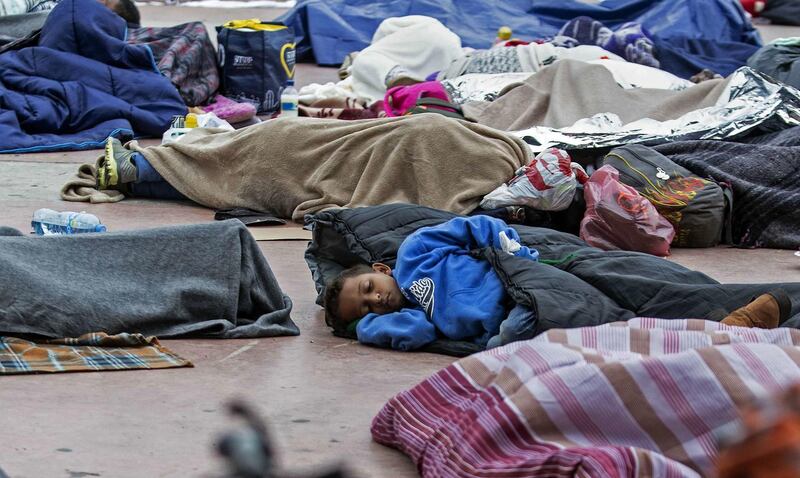 Central American migrants travelling in the "Migrant Via Crucis" caravan sleep outside "El Chaparral" port of entry to US while waiting to be received by US authorities, in Tijuana, Baja California State, Mexico on April 30, 2018. 
According to the U.S. Customs and Border Protection on Sunday, none of the migrants from the caravan was processed for asylum because the agency had reached capacity for the day for migrants seeking asylum. At least 150 Central American migrants reached the border between Mexico and the United States on Sunday, determined to seek asylum from the US. The group arrived in the Mexican border town of Tijuana, part of a caravan of more than 1,000 people who set out from Mexico's southern border on March 25.
 / AFP PHOTO / GUILLERMO ARIAS
