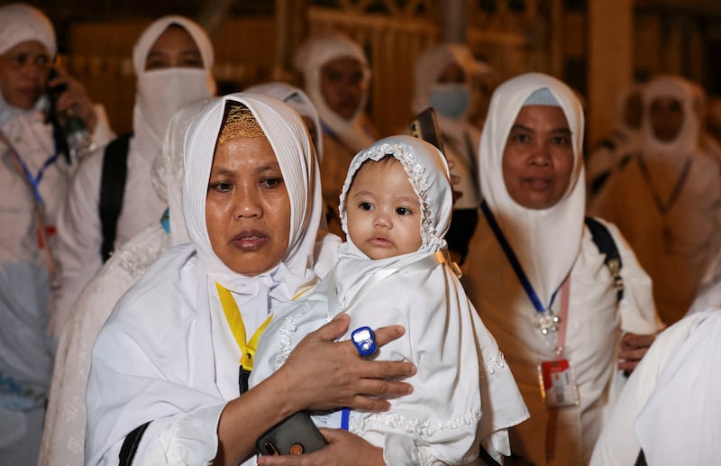 A woman carries a baby as pilgrims walk to climb Mount Arafat during the pilgrimage. Reuters