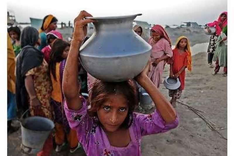 A girl displaced by flooding collects drinking water from a pump at a relief camp north of Dadu, Sindh province, this week.