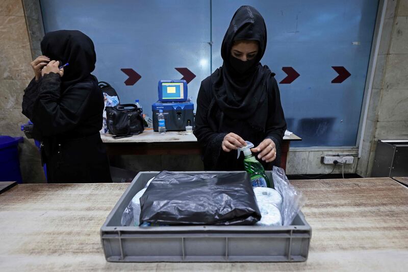 Afghan women airport workers are pictured at a security checkpoint of the airport in Kabul. AFP