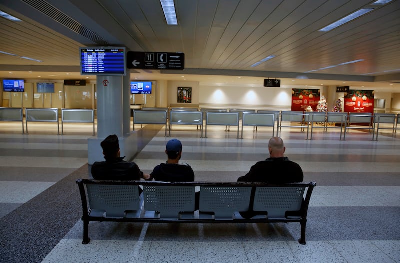 People wait at the almost empty arrival hall of the Rafik Hariri International Airport during a strike in Beirut, Lebanon, Friday, Jan. 4, 2019. Parts of Lebanon's public and private sectors have gone into a strike called for by the country's labor unions to protest worsening economic conditions and months of delays in the formation of a new government. (AP Photo/Bilal Hussein)