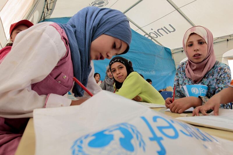 Young Syrian refugees sit at a UNICEF-run school in the al-Zaatari refugee camp in the Jordanian city of Mafraq near the border with Syria, on October 4, 2012. The school is a grant from the European Union to provide education to Syrian refugees residing in Jordan.  AFP PHOTO/KHALIL MAZRAAWI        (Photo credit should read KHALIL MAZRAAWI/AFP/GettyImages)