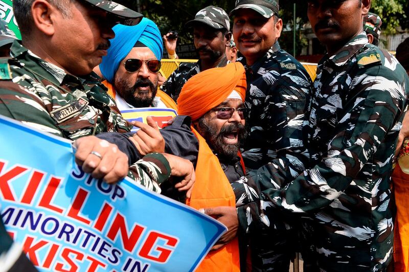 Centre Reserve Police (CRP) detain National Akali Dal President Paramjit Singh (centre) during a protest demanding US President Donald Trump to take action against Pakistan, in New Delhi, ahead of Trump's first official visit to India.  AFP