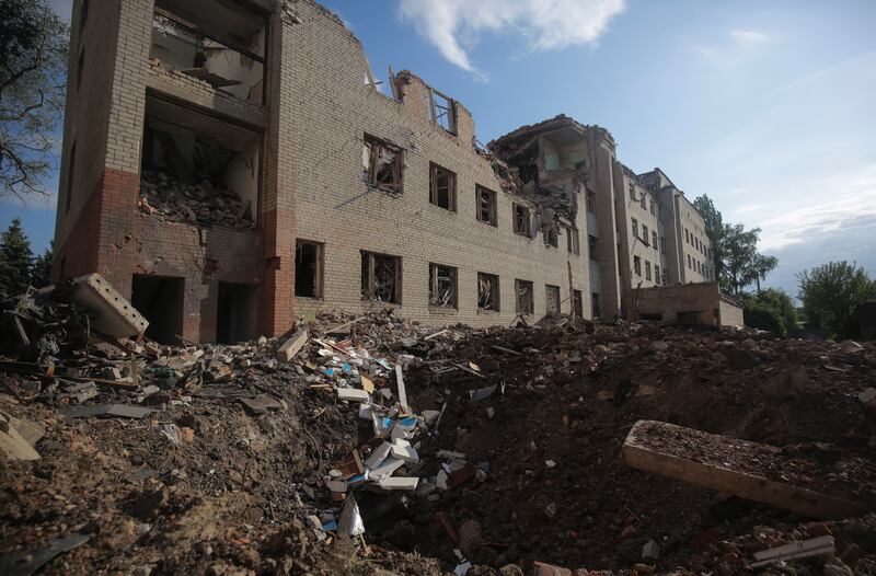 A shell hole near a destroyed building in Zaytseve village. EPA
