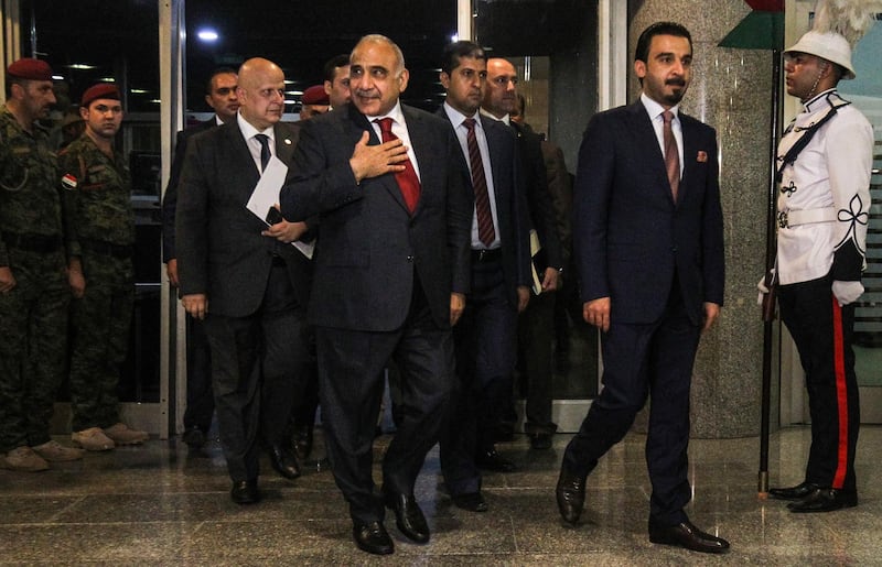 Iraq's prime minister designate Adel Abdel Mahdi (C-L) arrives with parliament speaker Mohamhed Halbusi (R) at the parliament headquarters in the capital Baghdad on October 24, 2018, prior to a vote on the former's new proposed cabinet.  / AFP / AHMAD AL-RUBAYE
