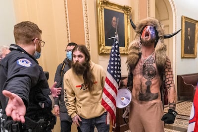 FILE - In this Wednesday, Jan. 6, 2021 file photo, supporters of President Donald Trump, including Jacob Chansley, right with fur hat, are confronted by U.S. Capitol Police officers outside the Senate Chamber inside the Capitol in Washington. Chansley made a written apology from jail, asking for understanding as he was coming to grips with his actions. (AP Photo/Manuel Balce Ceneta, File)