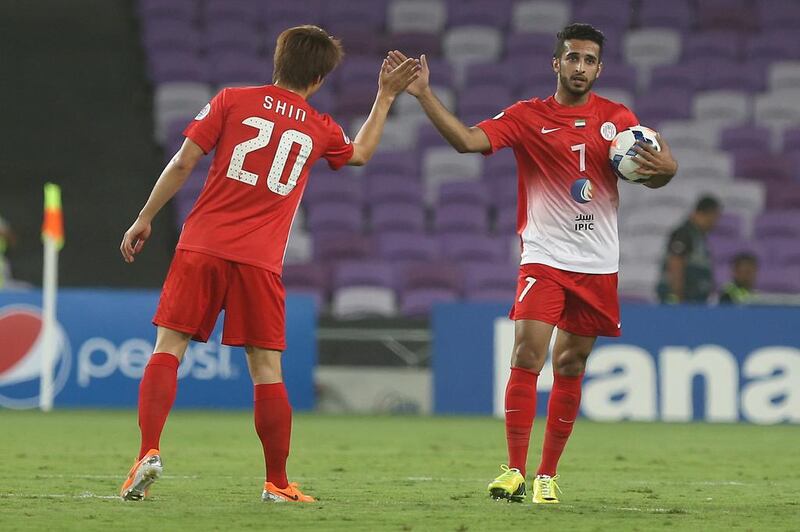 After scoring the first goal of the match, Al Jazira forward Ali Mabkhout gets a high five from teammate Shin Hyung-min during their loss to Al Ain in the Asian Champions League. Delores Johnson / The National / May 13, 2014