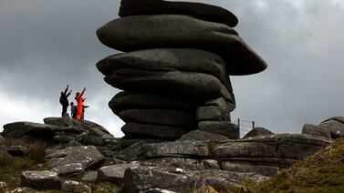 People react as they reach the climb up to a natural structure known as The Cheesewring on Bodmin Moor, near the village of Minions, Cornwall, Britain, April 24, 2024.  REUTERS / Kevin Coombs