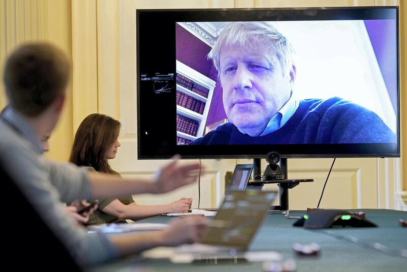 A handout picture released by 10 Downing Street, the office of the British prime minister on March 28, 2020, shows an image of Britain's Prime Minister Boris Johnson on a screen as he remotely chairs the morning novel coronavirus Covid-19 meeting by video link, in Downing Street in central London. - The two men leading Britain's fight against the coronavirus -- Prime Minister Boris Johnson and his Health Secretary Matt Hancock -- both announced Friday they had tested positive for COVID-19, as infection rates accelerated and daily death rate rose sharply. (Photo by Andrew PARSONS / 10 Downing Street / AFP) / RESTRICTED TO EDITORIAL USE - MANDATORY CREDIT "AFP PHOTO / 10 DOWNING STREET / ANDREW PARSONS / HANDOUT" - NO MARKETING - NO ADVERTISING CAMPAIGNS - DISTRIBUTED AS A SERVICE TO CLIENTS