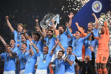 (FILES) Manchester City's German midfielder #8 Ilkay Gundogan (C) lifts the European Cup trophy as they celebrate on the podium after winning the UEFA Champions League final football match between Inter Milan and Manchester City at the Ataturk Olympic Stadium in Istanbul, on June 10, 2023.  Manchester City wins its first European Cup trophy, in Istanbul, on 10 June 2023, joining the big leagues of Europe.  (Photo by FRANCK FIFE  /  AFP)