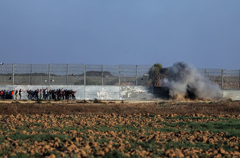 Palestinian protesters detonate a bomb at the border wall during clashes on the eastern border of the Gaza Strip on Friday. EPA