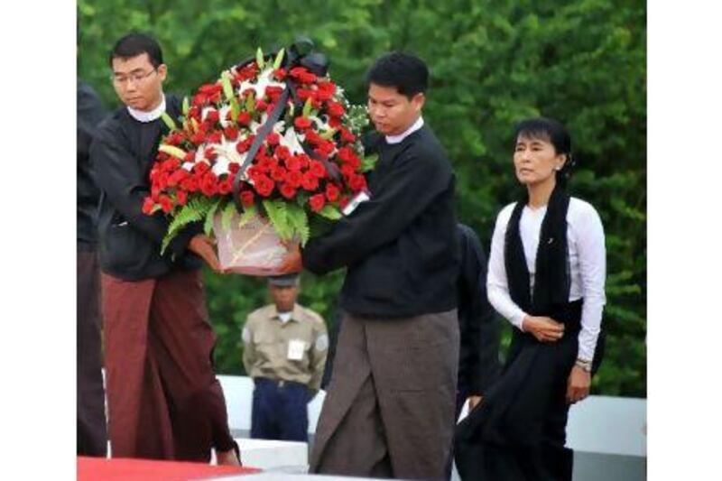 Aung San Suu Kyi arrives with a wreath to pay her respects to her father, the late General Aung San, and eight other leaders who were assassinated on July 19, 1947, at the official ceremony marking the 64th anniversary of Martyrs' Day at a mausoleum near the Shwe Dagon Pagoda in Yangon yesterday.