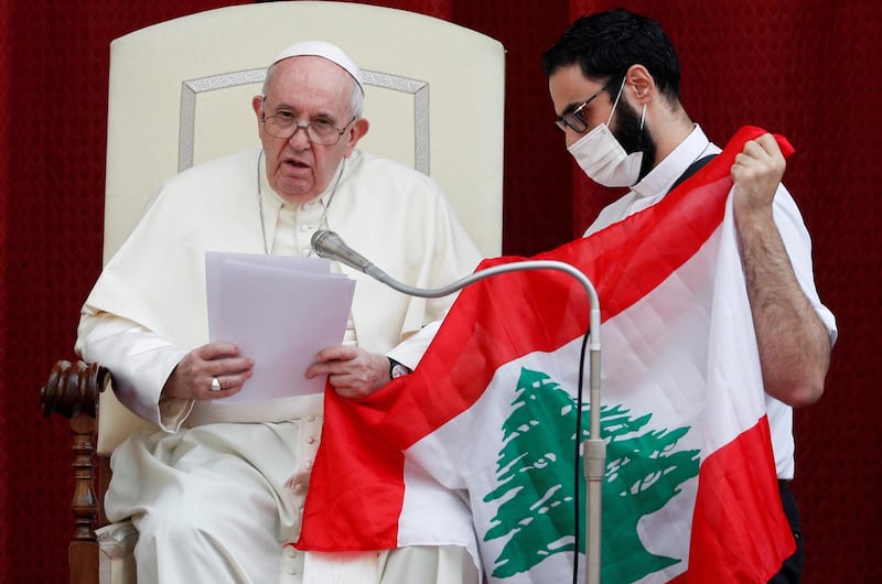 Pope Francis and a faithful hold a Lebanese flag as they pray for the country, following an explosion in Beirut, during the first weekly general audience to readmit the public since the coronavirus disease (COVID-19) outbreak, in the San Damaso courtyard, at the Vatican, September 2, 2020. REUTERS/Guglielmo Mangiapane     TPX IMAGES OF THE DAY