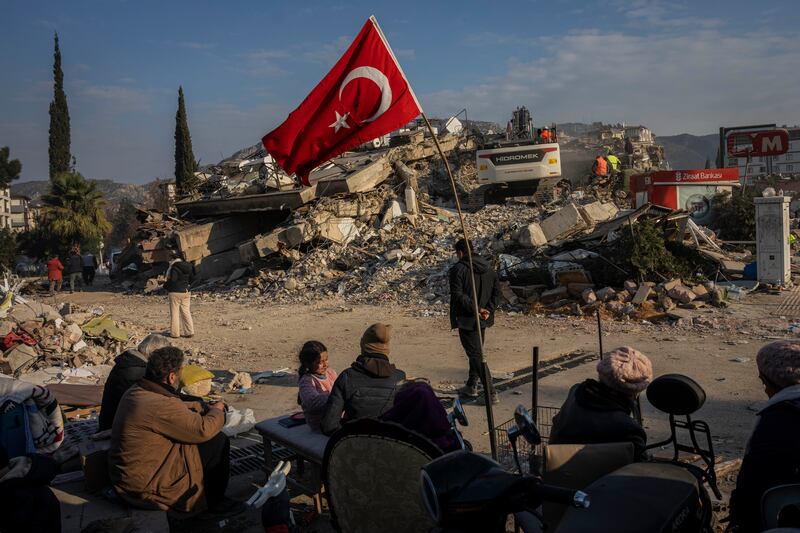 A family wait for the bodies of their relatives to be recovered in Antakya, Turkey. AP