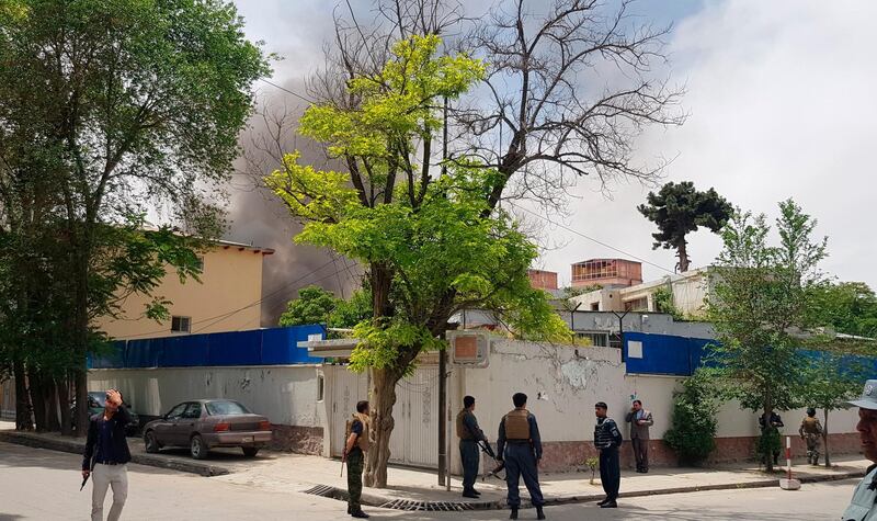 Afghan security personnel watch as smoke rises after the explosion. AP