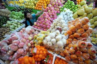 A vendor arranges round-shaped fruit at a market in suburban Manila on December 27, 2010.  Some Filipinos believe that displaying 12 different round-shaped fruits - one representing each month of the year - at home before New Year's Day welcomes prosperity.   AFP PHOTO/NOEL CELIS (Photo by NOEL CELIS / AFP)
