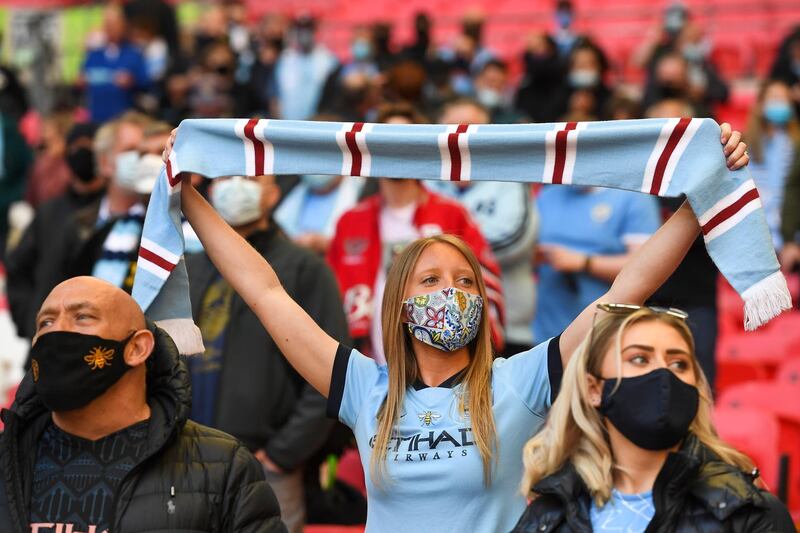 Fans of Manchester City wear protective face masks in the stands prior to the English League Cup final at Wembley in London. EPA