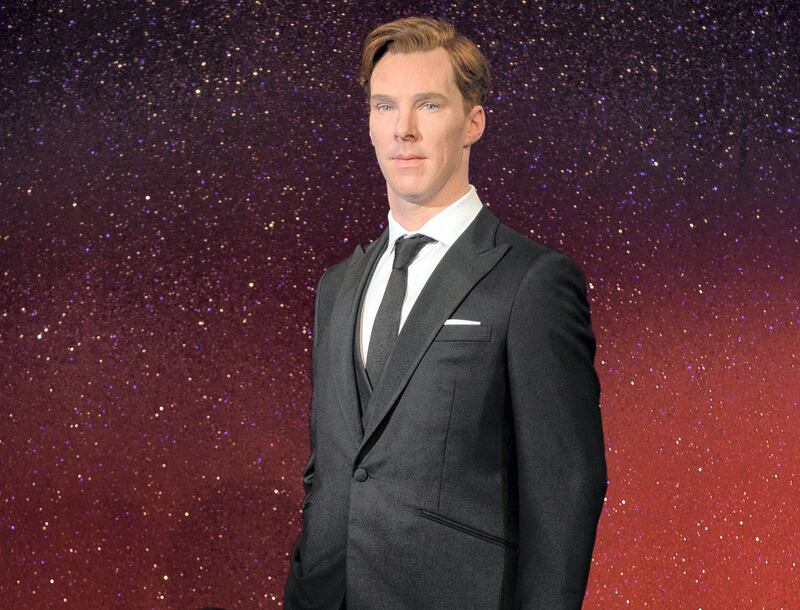 Stylists Claire Galvin (L) poses with the new wax figure of British actor Benedict Cumberbatch as it is unveiled at Madame Tussauds in central London on October 21, 2014. Dressed in a dark suit the figure of Cumberbatch has been modelled to be "premiere ready".  AFP PHOTO / LEON NEAL (Photo by LEON NEAL / AFP)