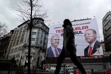 People pass in front of a huge banner with pictures of Turkish President Recep Tayyip Erdogan and Binali Yildirim, candidate of Turkish ruling party Justice and Development Party (AKP) reading 'Thank you Istanbul' in Istanbul, Turkey, 2 April, 2019. EPA