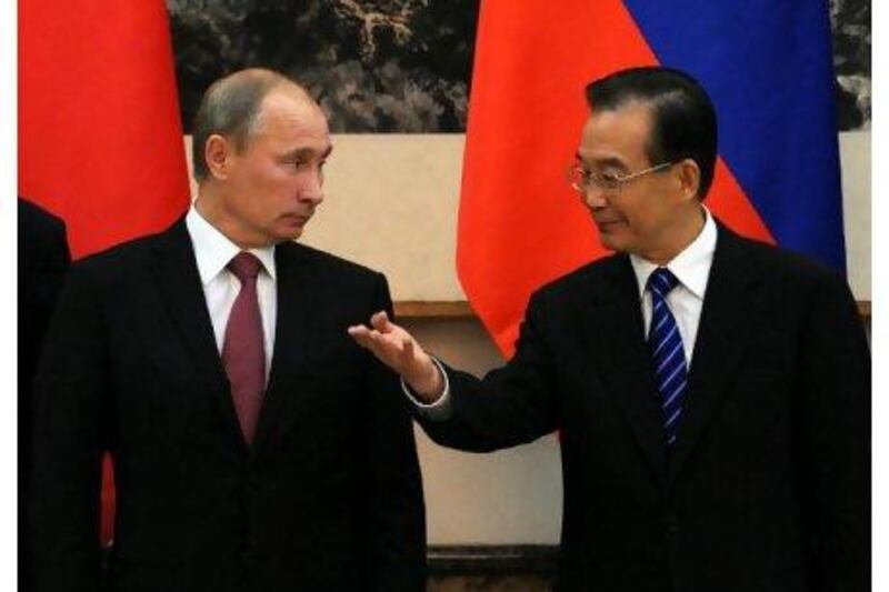 China's premier, Wen Jiabao, right, gestures to the Russian prime minister, Vladimir Putin, during a signing ceremony at the Great Hall of the People in Beijing yesterday. Takuro Yabe / AP Photo