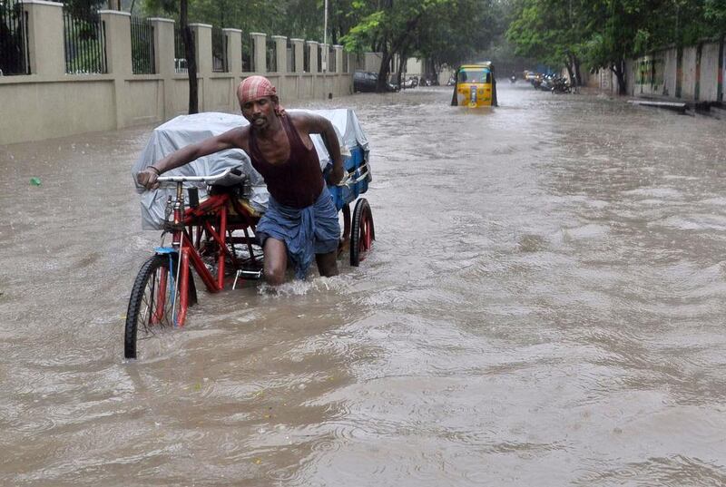 A man pushes his cycle trishaw through floodwaters in Chennai, southern India. AFP Photo