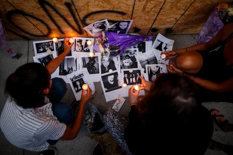 Friends of 18-year-old shooting victim Reese Fallon leave candles at a memorial on Danforth Avenue in Toronto. Mark Blinch / The Canadian Press via AP