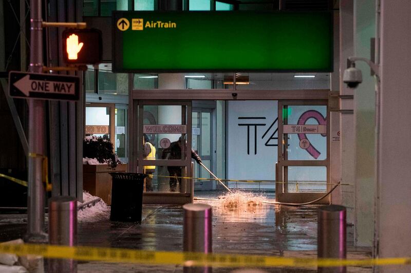 Workers sweep water from a floor of the arrivals area at John F. Kennedy International Airport's terminal 4, in New York on January 7, 2018. 
International flights were suspended into a flooded terminal at New York's flagship airport on Sunday, flung into chaos after a water main broke during brutally cold temperatures following a deadly winter storm. Gushing water compounded meltdown at John F. Kennedy International Airport, where furious passengers have camped out for days as a result of equipment damaged by the storm and a backlog of flights.
 / AFP PHOTO / Jewel SAMAD