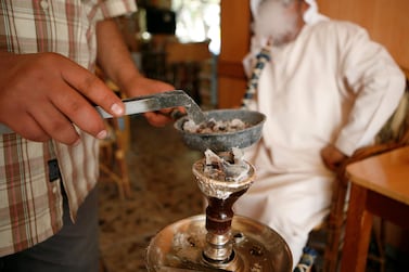 Sulieman Ali smokes shisha in an Abu Dhabi cafe. Ryan Carter / The National