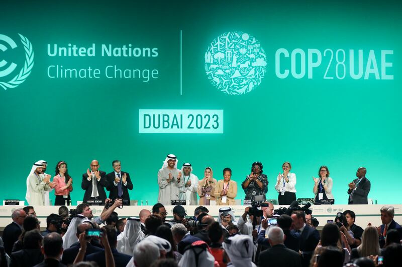 Diplomats applaud after a climate deal was approved following all-night negotiations at Dubai's Expo City. Getty Images