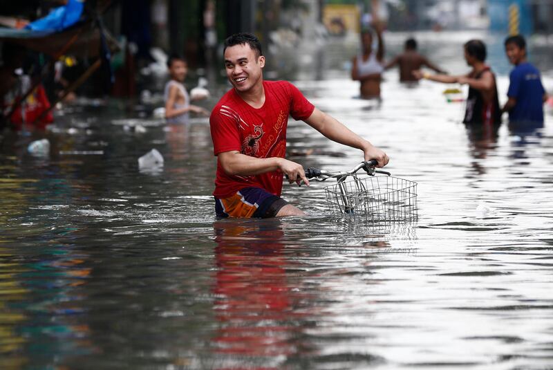 A Filipino rides his bicycle through floodwaters in Quezon City. Rolex De La Pena / EPA