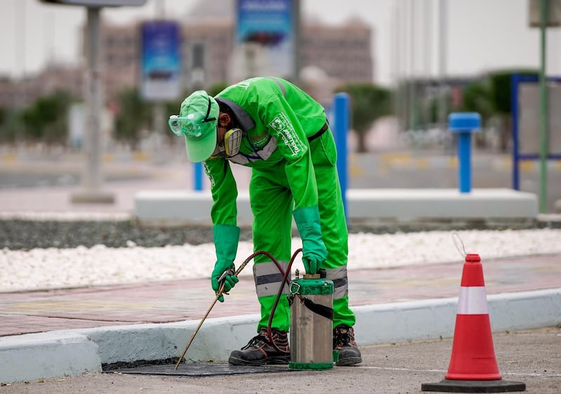 Abu Dhabi, United Arab Emirates, April 13, 2020.  A Tadweer worker sanitises the gutters at the Marina Mall parking lot.
Victor Besa / The National
Section:  NA
For:  Standalone