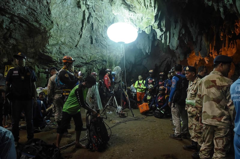 Thai rescue personnel are set up at the entrance of Tham Luang cave under floodlights to conduct operations to find the missing members of the children's football team along with their coach at the cave in Khun Nam Nang Non Forest Park in Chiang Rai province on June 26, 2018.  / AFP / LILLIAN SUWANRUMPHA
