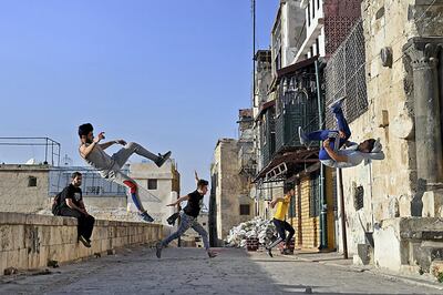 Syrian youths practise parkour in Aleppo, northern Syria, on April 7, 2018.
In the absence of special facilities and equipment for the sport, such as padding to protect against falls, athletes often risk serious injury. And parkour in east Aleppo comes with an additional challenge: remnants of war.  / AFP PHOTO / George OURFALIAN