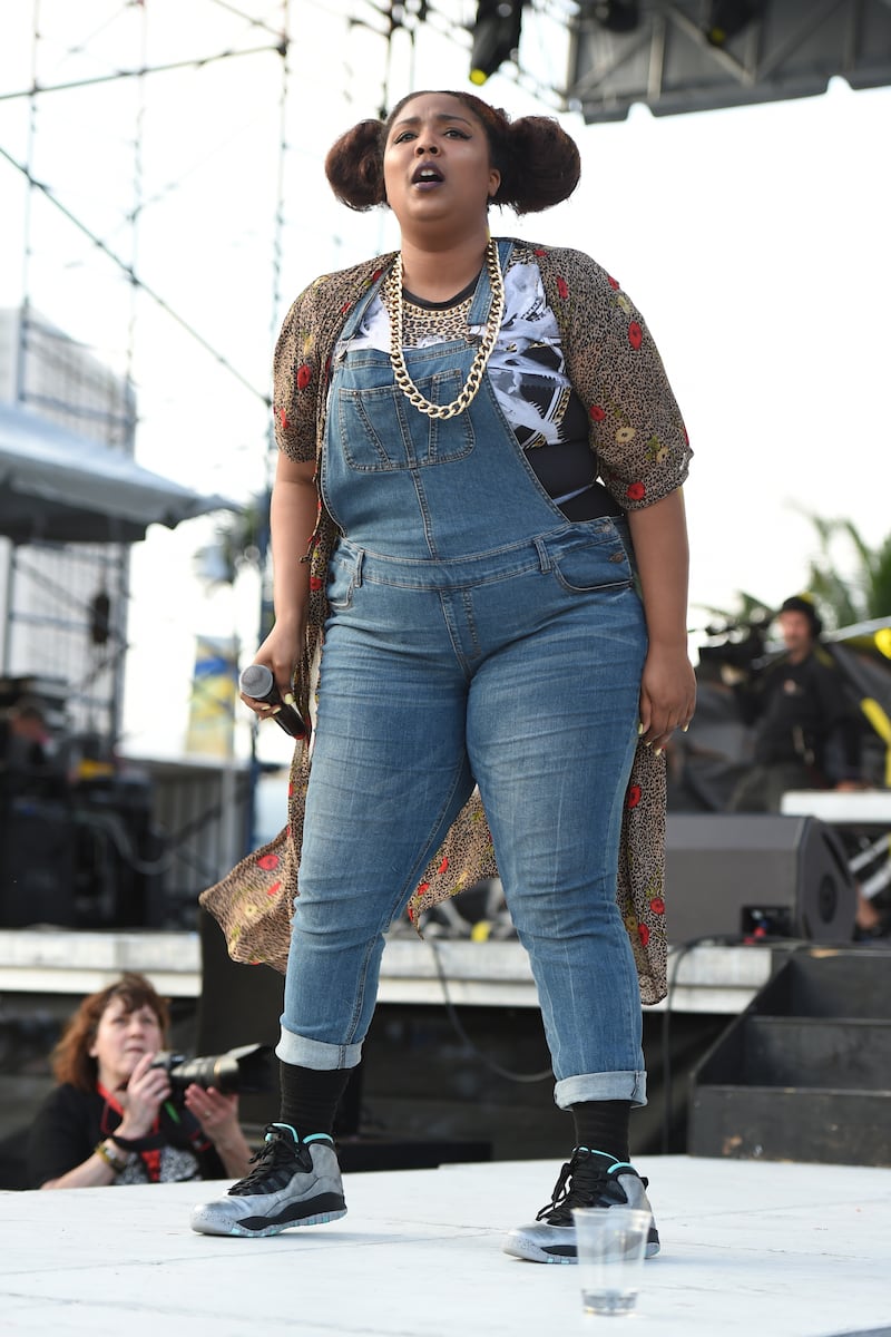 Lizzo performs in dungarees and a T-shirt with her hair in bunches during Sunfest on April 29, 2015. Getty Images