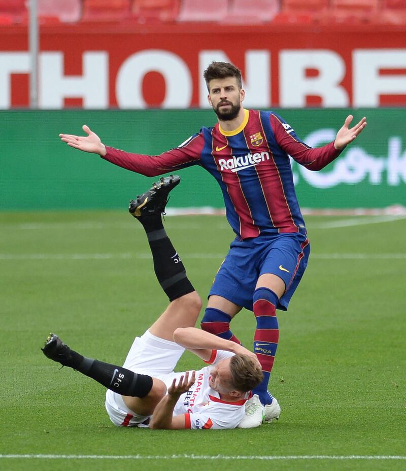 Barcelona defender Gerard Pique pleads his innocence as Sevilla's Luuk De Jong holds his head. AFP
