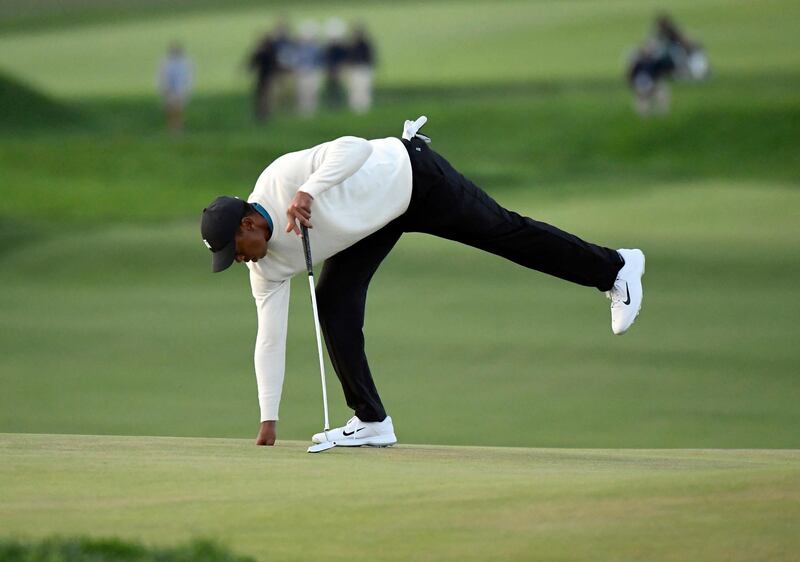 Tiger Woods holes out on the ninth green. USA Today
