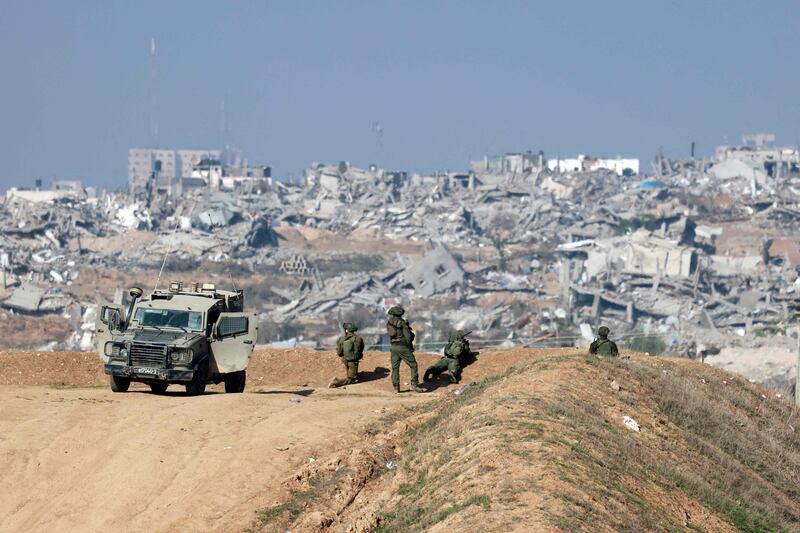 Israeli soldiers watch from a vantage point overlooking Gaza city amid fighting with Hamas. AFP