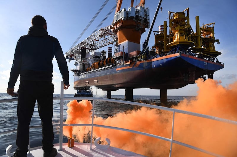 French sailor Clement Brochot stands on the deck of the fishing boat 'Galaxy III' in front of the drilling platform ship 'Aeolus'  in the Bay of Saint-Brieuc, western France, to protest against the planned construction of 62 wind turbines in the bay. AFP