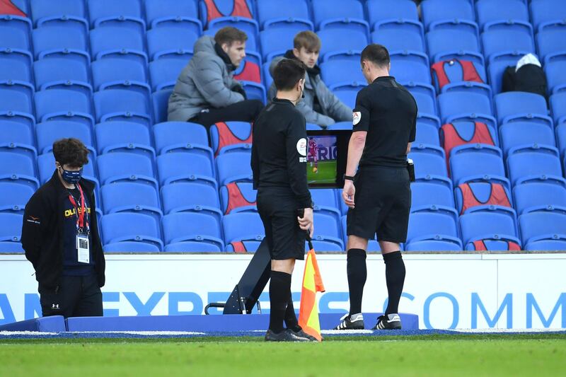 Referee Stuart Attwell checks the pitch-side VAR monitor, before awarding Brighton a late penalty. Getty