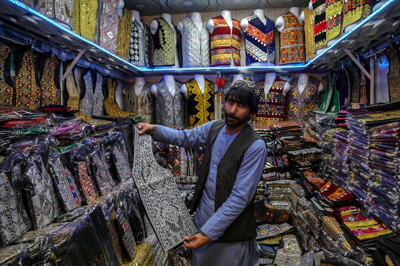 An Afghan shopkeeper arranges his traditional clothing wares in the capital Kabul. EPA