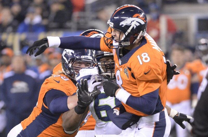 Quarterback Peyton Manning of the Denver Broncos fires a pass as he's hit by a Seattle Seahawks defender during the Super Bowl on Sunday. Timothy A Clary / AFP 