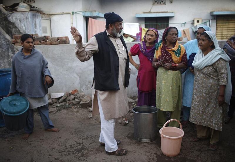 A local leader Hajibhai speaks with women who inquire about the water issues.