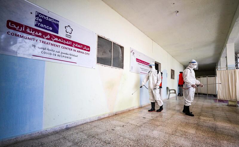 Medical workers disinfect a hallway at a quarantine area in the Syrian town of Ariha in the rebel-held northwestern Idlib province. AFP