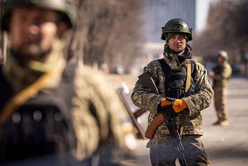 Ukrainian servicemen stand guard at a military check point in Kyiv after at least eight people were killed in the bombing of a shopping centre. The 10-storey building was completely destroyed in the blast.  AFP