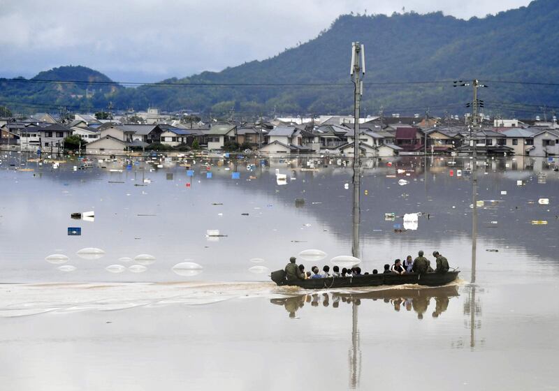 Residents are rescued from a flooded area by Japan Self-Defense Force soldiers in Kurashiki, southern Japan. Reuters