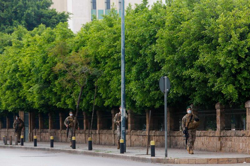 Lebanese army soldiers, wearing protective face masks, patrol a street in the capital Beirut.  AFP