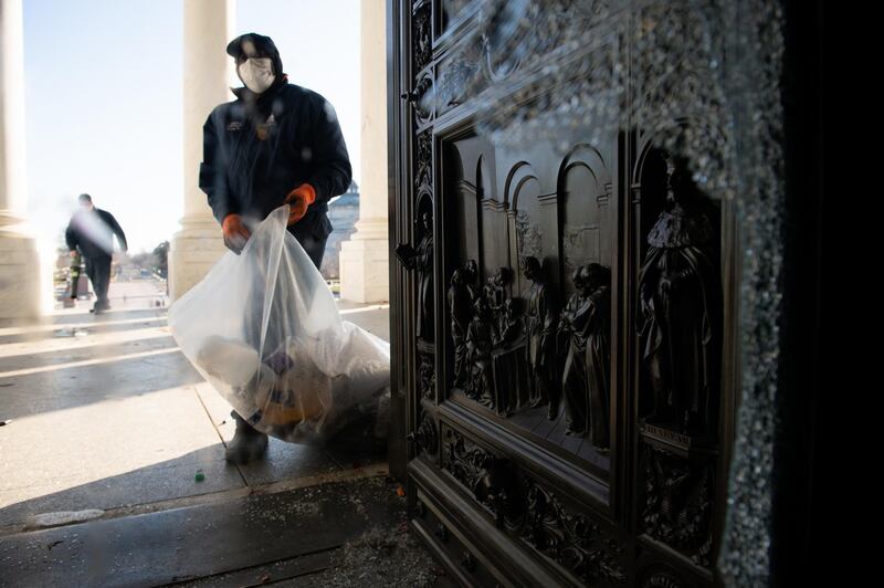 Workers clear trash from the East Front of the US Capitol building in Washington. Bloomberg